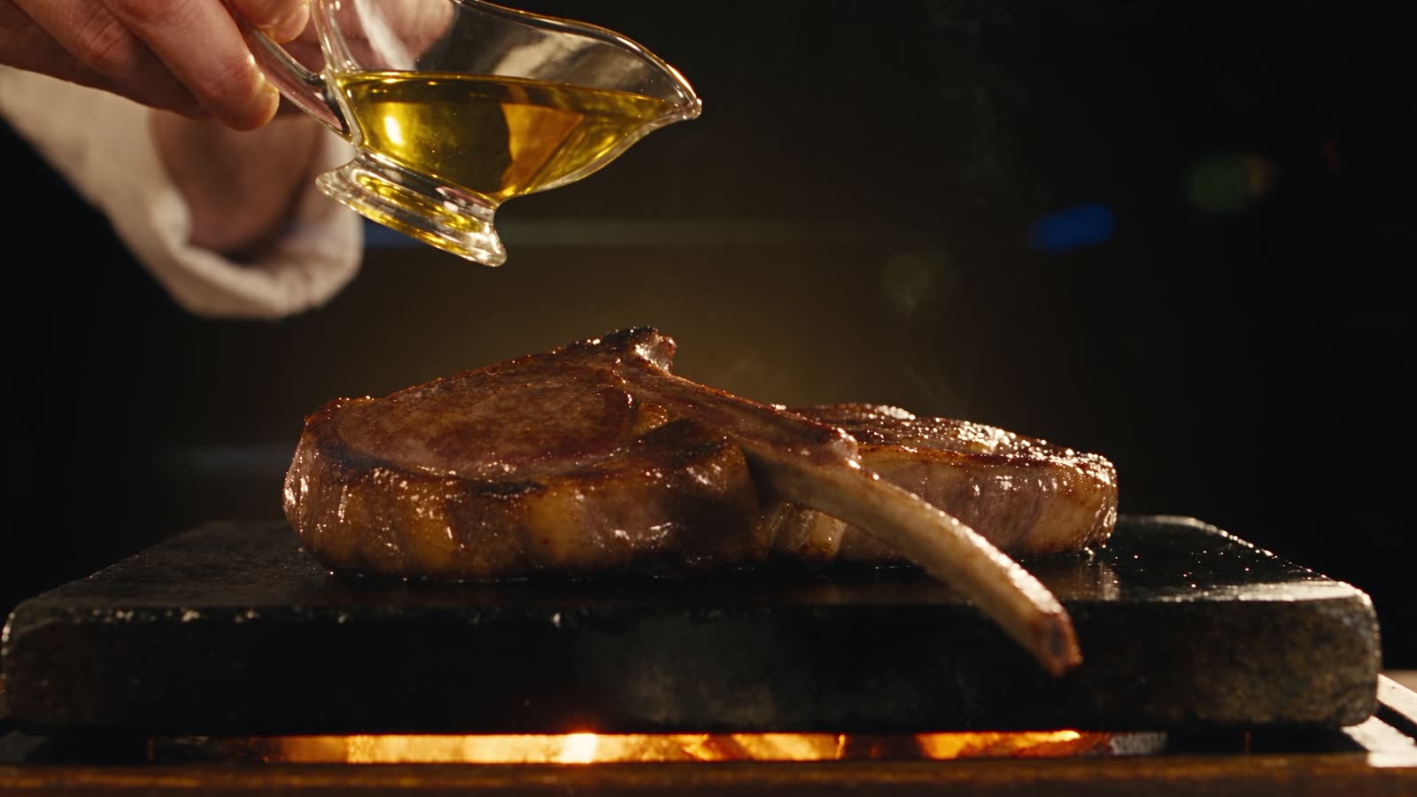 Lamb chops on hot black stone with olive oil